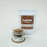 Roasted hojicha green tea powder being whisked with hot water in a bowl